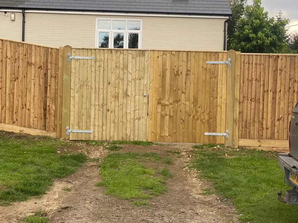 Double timber gates within a closeboard boundary fence