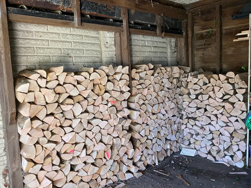 Split firewood logs stacked inside a timber shed